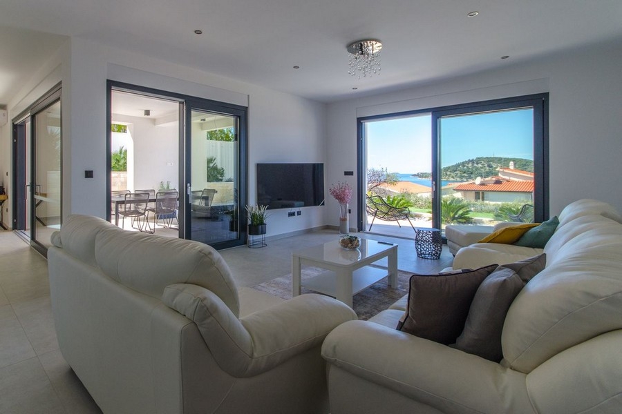 Séjour clair avec grande façade vitrée et vue mer