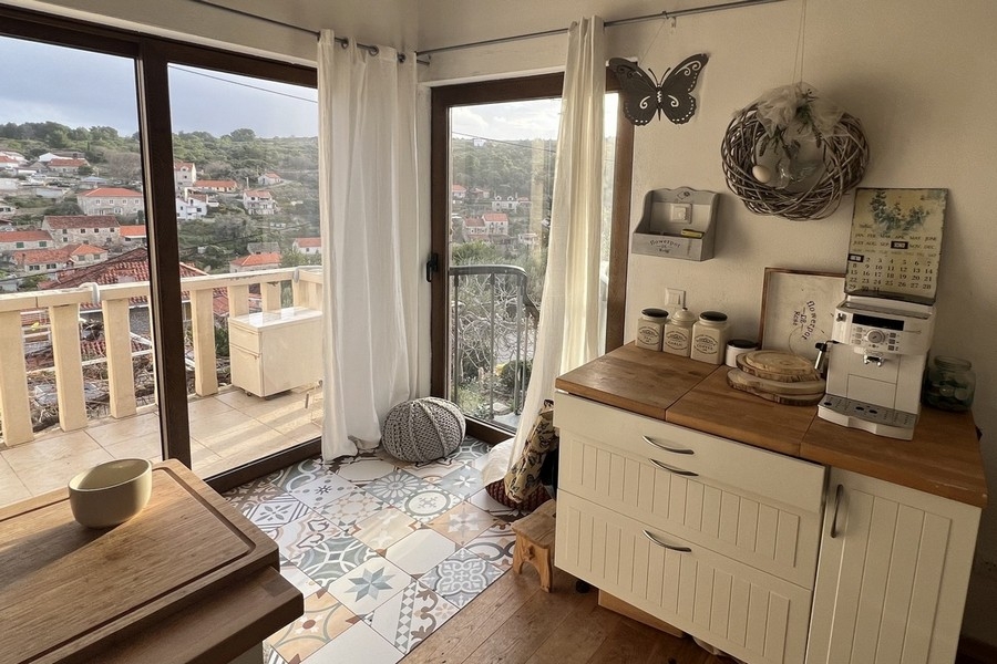 Coin cuisine avec fenêtres du sol au plafond et accès au balcon
