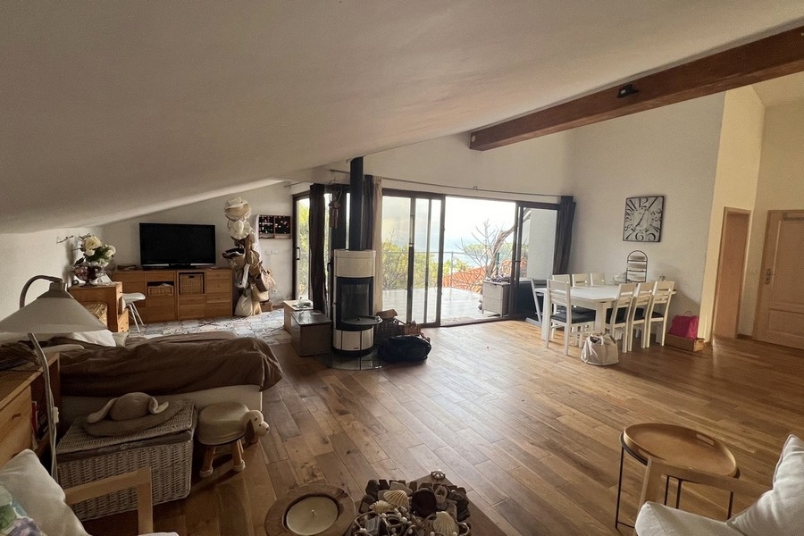 Séjour et coin repas ouverts avec poêle et fenêtres panoramiques