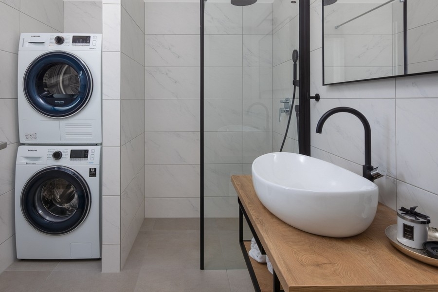 Salle de bains moderne avec douche et lave-linge