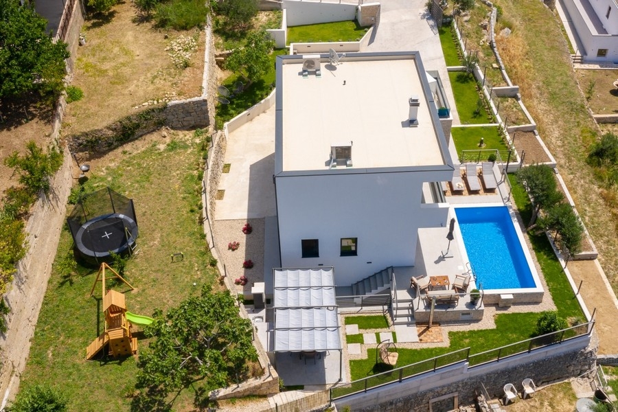 Vue aérienne de la villa avec piscine, jardin et aire de jeux
