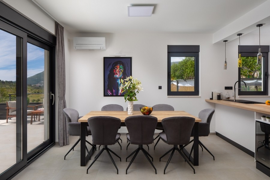 Coin repas avec accès à la terrasse et vue sur la verdure