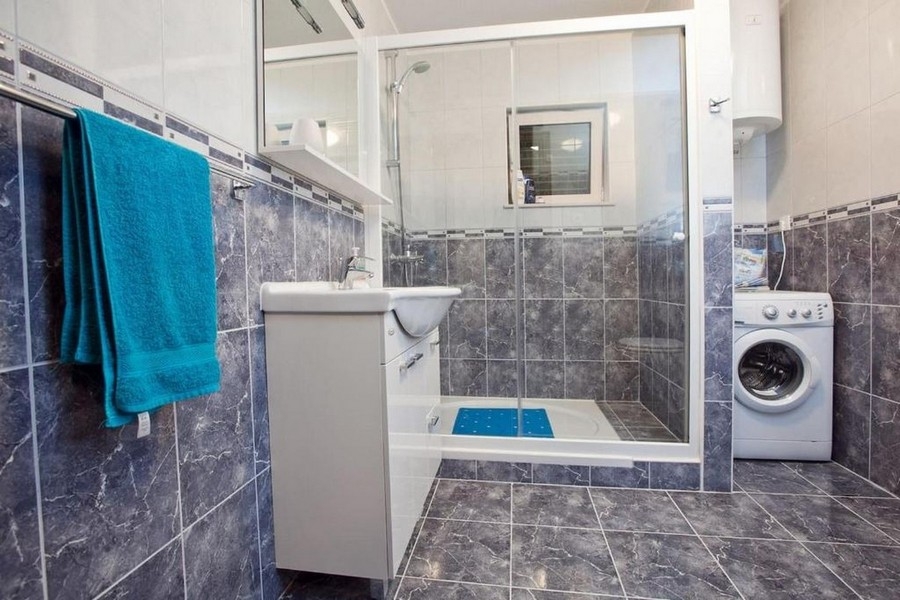 Salle de bains avec douche et lave-linge