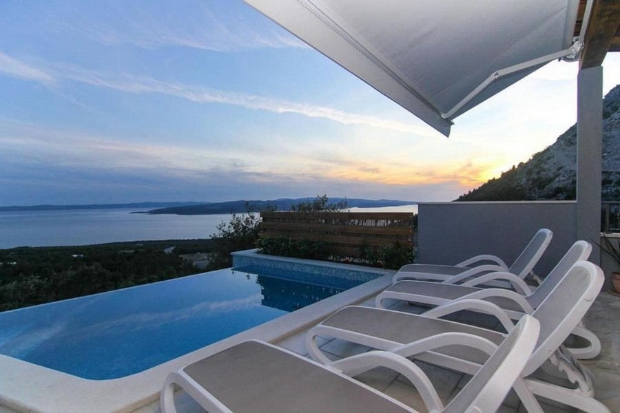 Terrasse de la piscine avec bains de soleil et vue mer