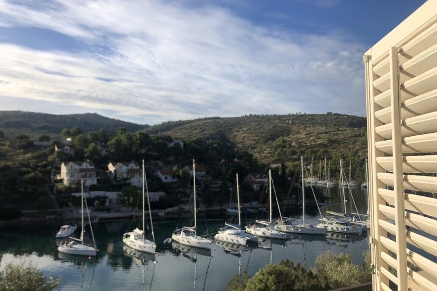 Vue mer depuis le balcon avec voiliers dans la baie