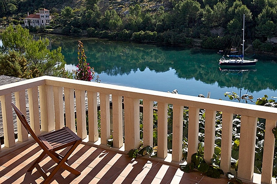 Balcon avec vue sur la baie tranquille et un voilier
