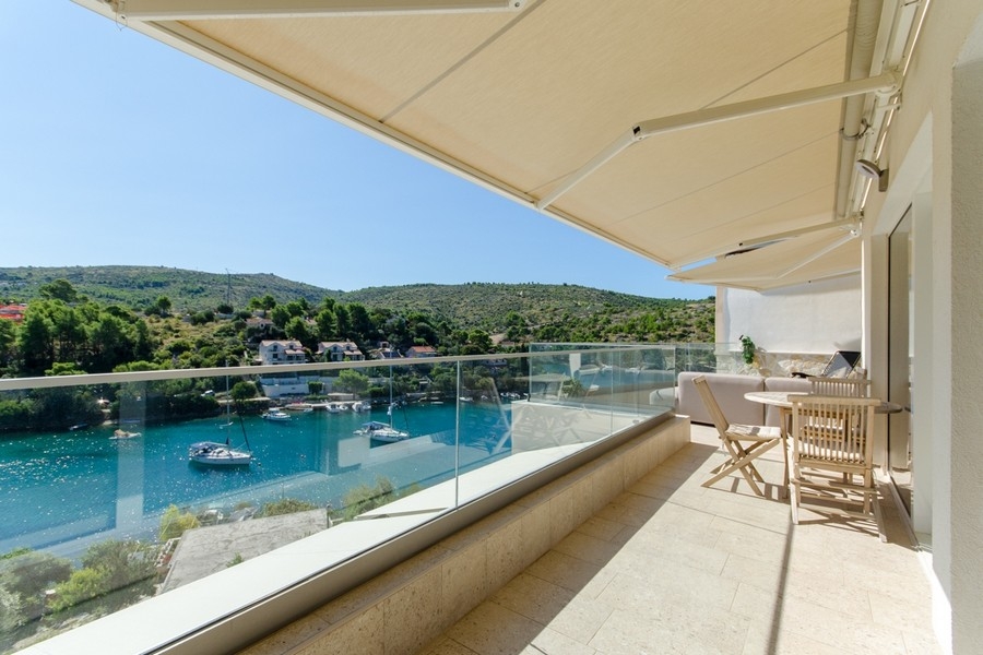Balcon avec garde-corps en verre et vue sur la baie de Brač
