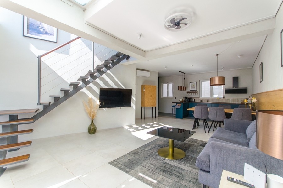 Séjour moderne avec escalier et cuisine ouverte