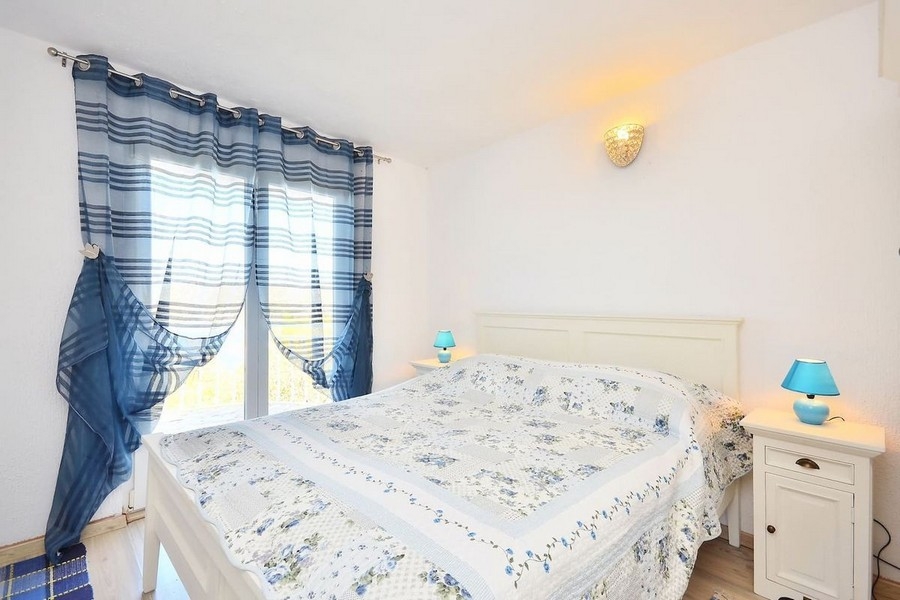Chambre avec lit double et rideaux bleus
