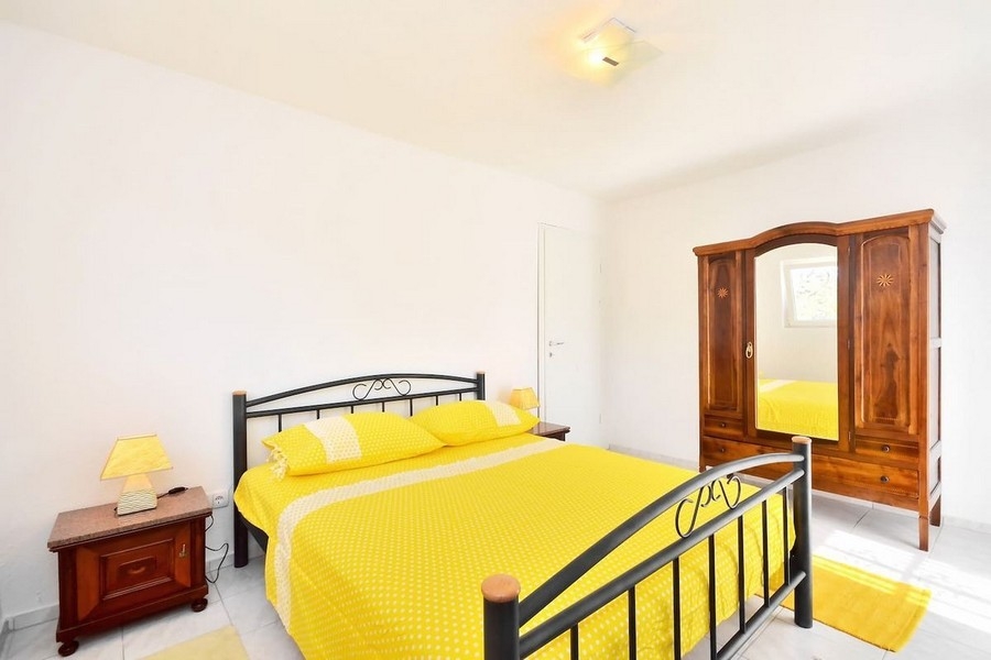 Chambre avec lit jaune et penderie