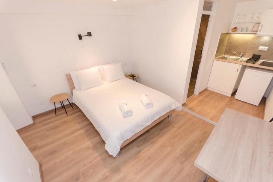 Espace nuit avec lit double et petite cuisine dans l'appartement