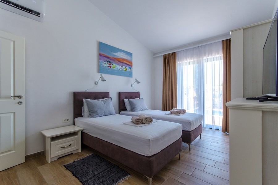 Chambre avec deux lits simples et accès au balcon