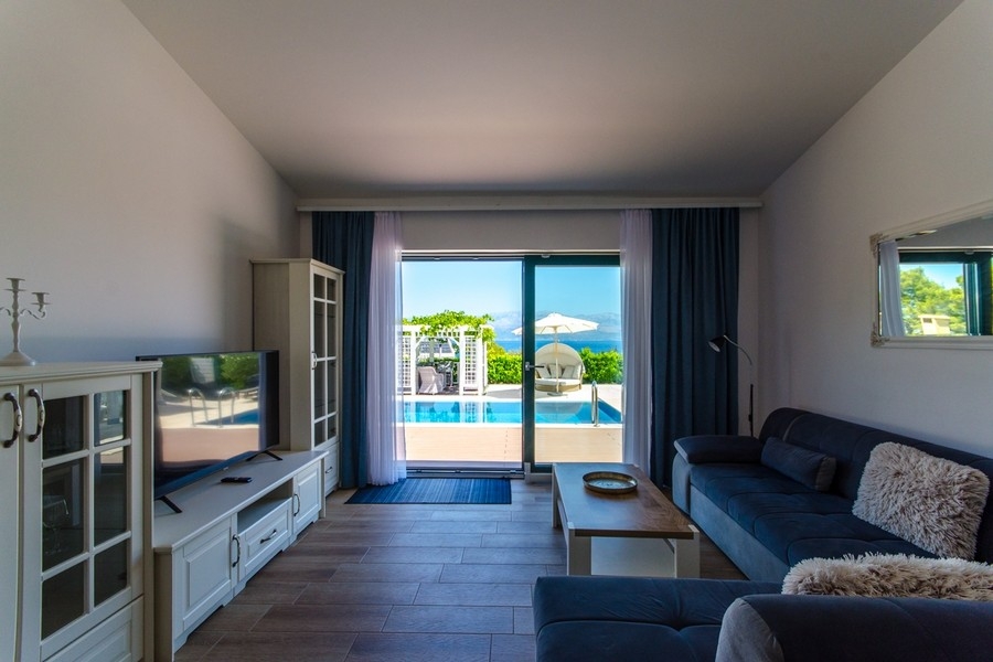 Salon avec accès à la terrasse et vue sur la piscine