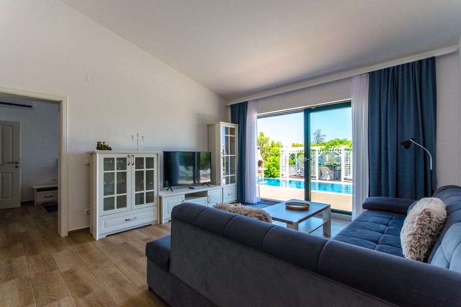 Salon avec vue sur la terrasse et l'espace piscine