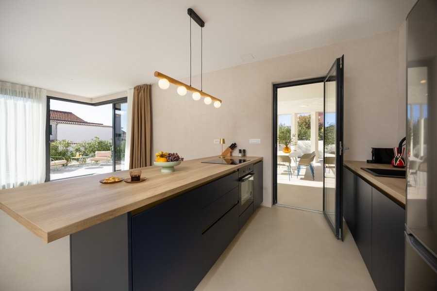 Cuisine moderne avec îlot et accès à la terrasse