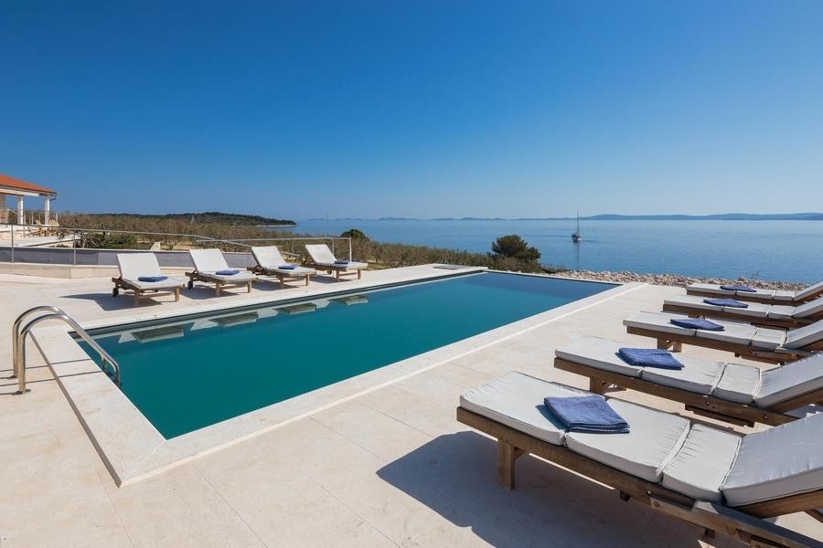 Piscine avec solarium et vue sur la mer