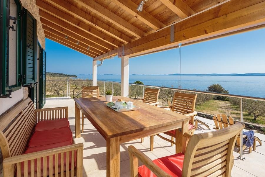 Terrasse couverte avec table et vue mer