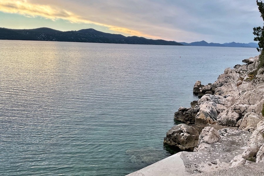 Côte rocheuse et mer cristalline devant le bien