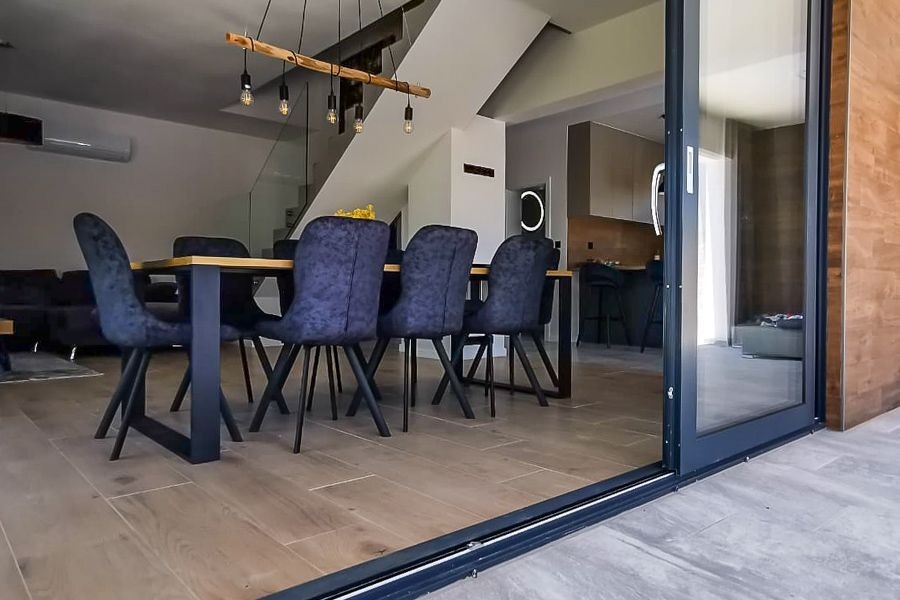 Coin repas avec accès à la terrasse et à l'espace piscine