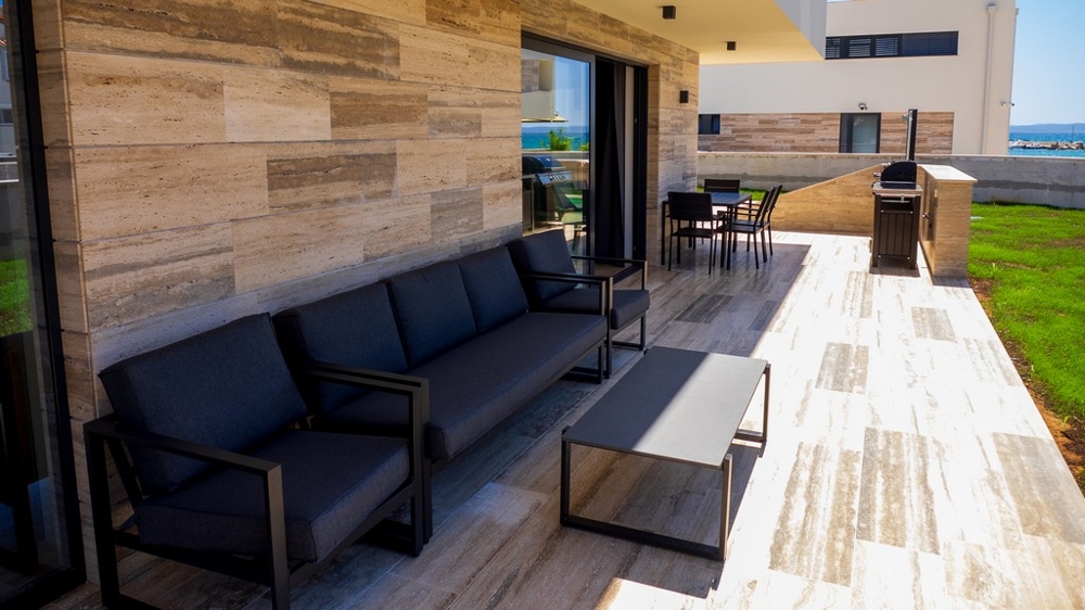 Terrasse couverte avec lounge et espace barbecue