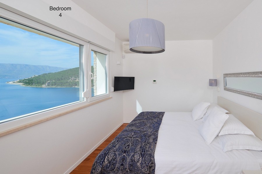 Chambre avec fenêtre panoramique et vue sur la mer et l'île