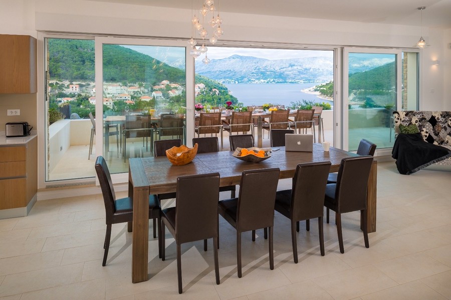 Séjour avec grande table à manger et fenêtres panoramiques avec vue mer