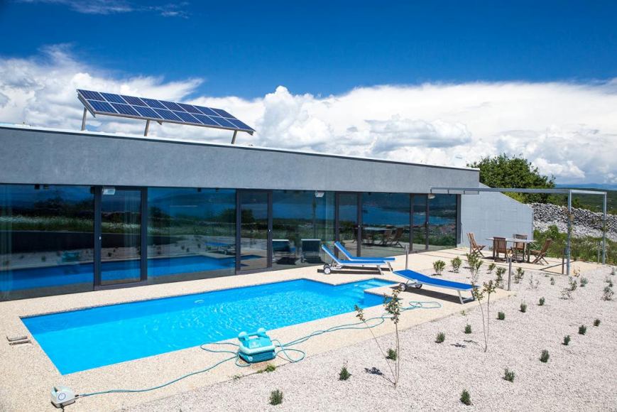 Villa avec panneaux solaires et piscine sur la surface de gravier