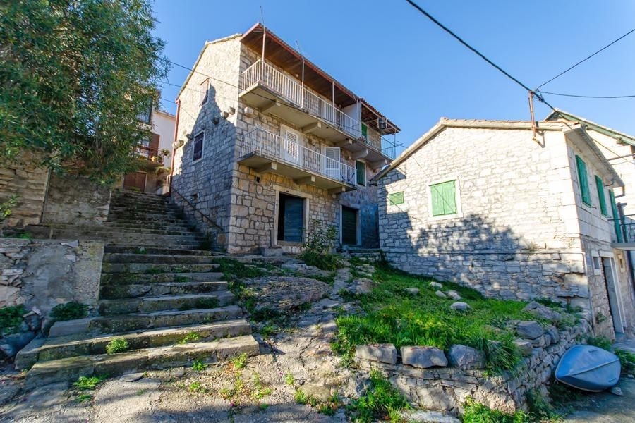 Ancienne maison en pierre avec balcons en bois au-dessus de l'escalier extérieur