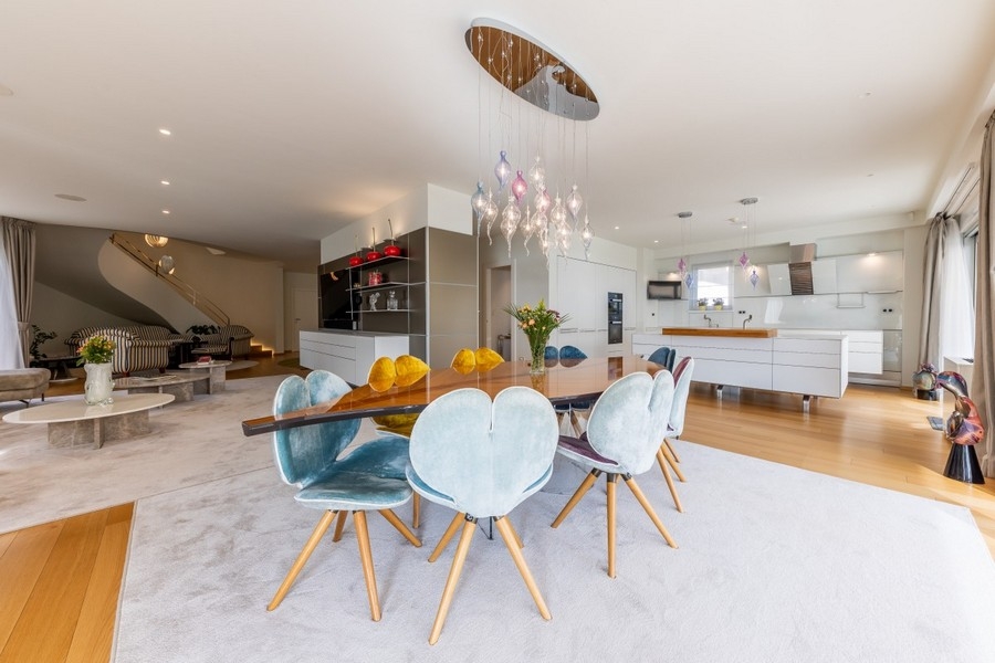 Coin repas ouvert avec luminaire design et cuisine moderne