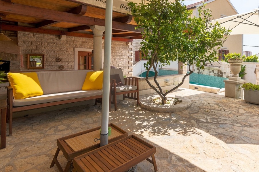 Espace extérieur couvert avec salon lounge et arbre