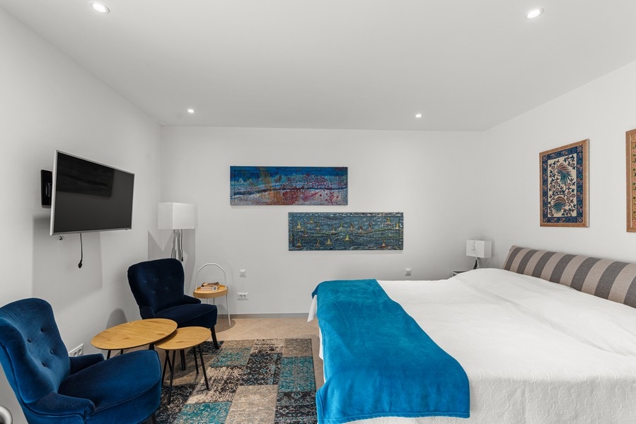 Chambre avec grand lit double et coin salon