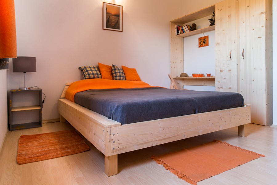 Chambre avec lit en bois et placard intégré