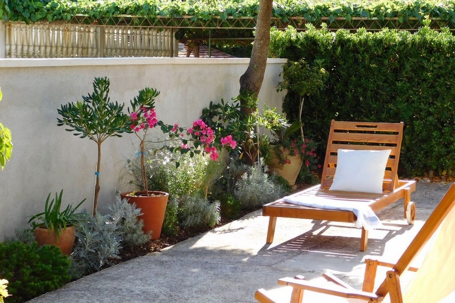 Terrasse avec chaise longue et plantes méditerranéennes dans le jardin