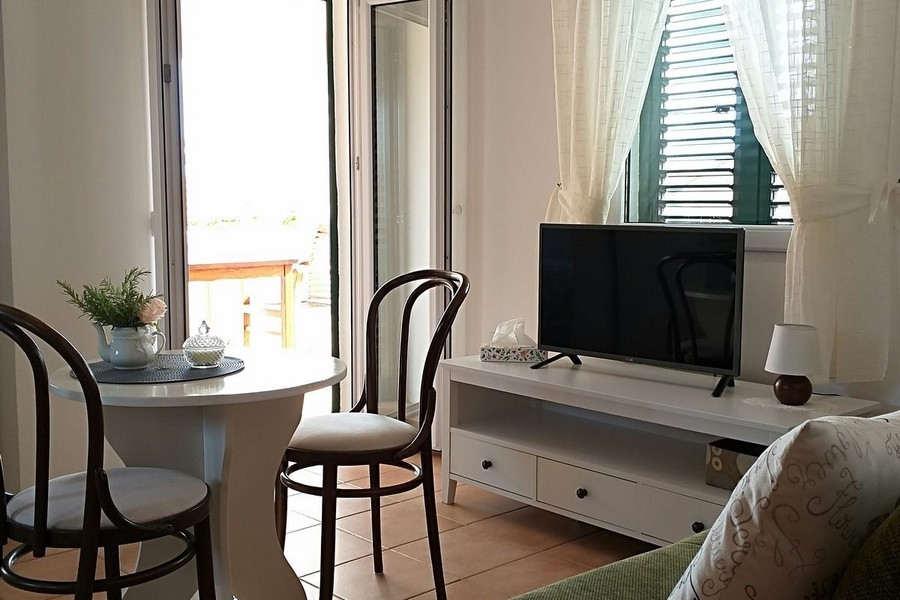 Salon avec table à manger et accès à la terrasse