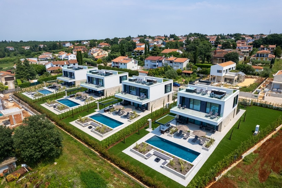 Vue aérienne de plusieurs villas blanches avec piscines privées
