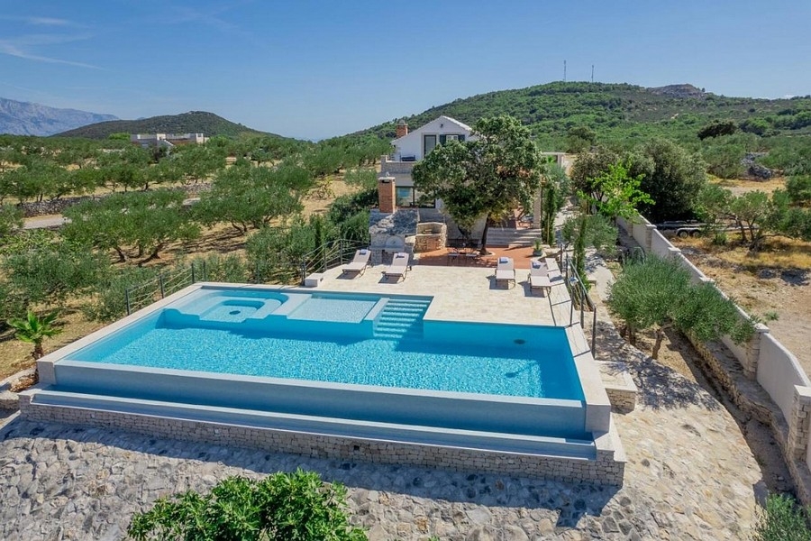 Piscine avec transats devant la maison dans l'oliveraie