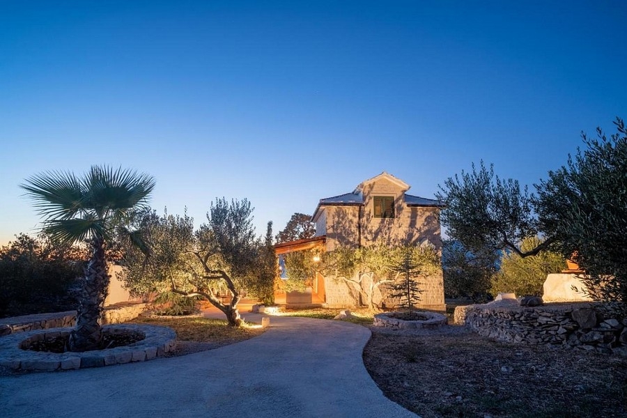Maison dalmate dans l'ambiance du soir avec jardin éclairé