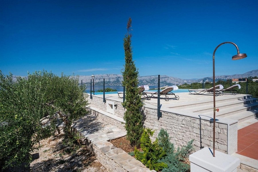 Terrasse avec piscine à débordement et vue panoramique sur la mer et la côte