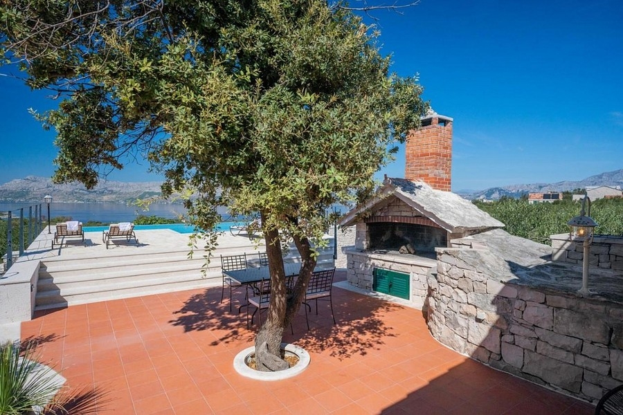 Espace extérieur avec coin barbecue et terrasse de la piscine avec vue mer