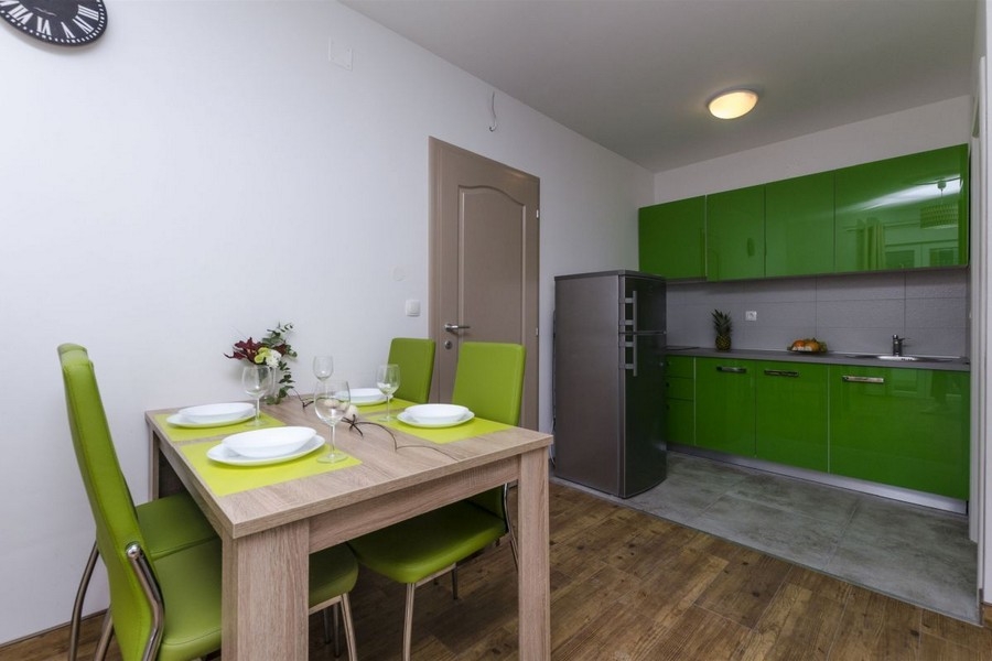 Cuisine équipée verte avec coin repas