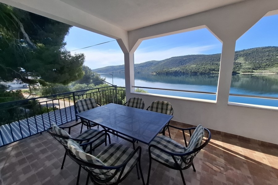 Espace extérieur couvert avec table à manger et vue sur la mer