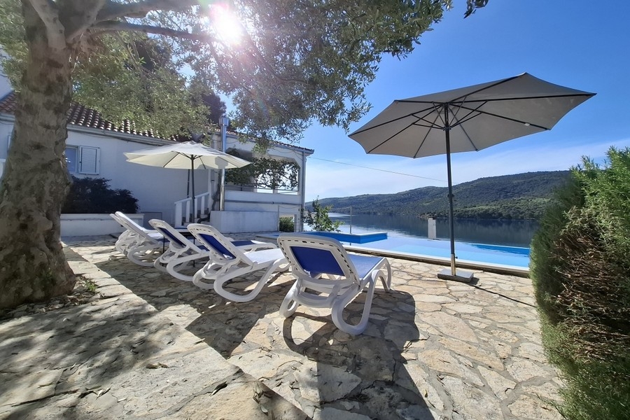Espace piscine avec parasols et chaises longues au bord de l'eau