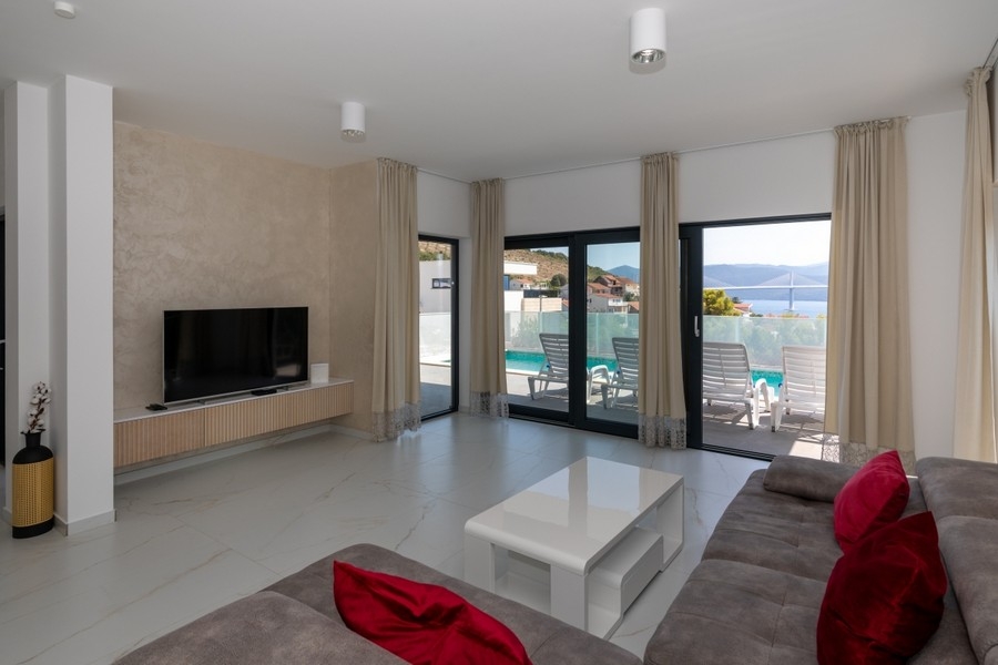 Salon moderne avec accès à la terrasse et à la piscine