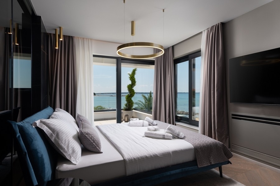 Chambre avec grandes fenêtres et vue mer en Croatie