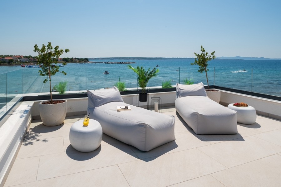 Toit-terrasse avec espaces de détente et vue panoramique sur la mer