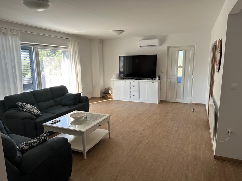 Salon avec canapé, TV et accès au balcon à l'équipement moderne