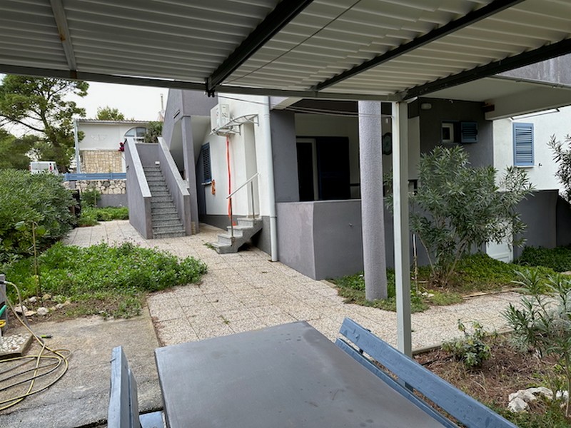 Espace extérieur avec terrasse, pergola et accès aux logements