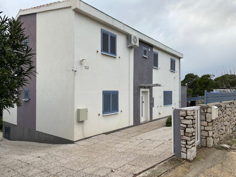 Façade de la maison avec entrée et place de stationnement sur terrain clos en Croatie