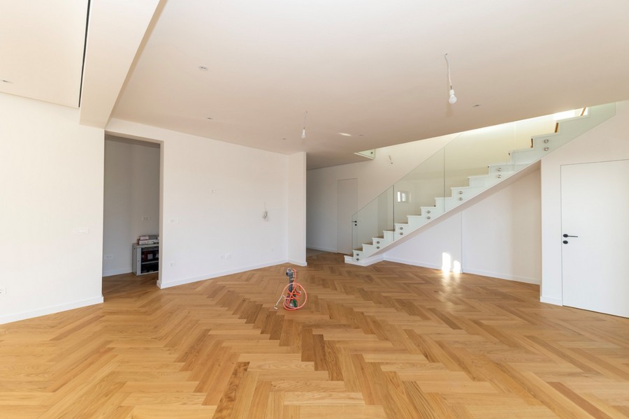 Séjour lumineux avec parquet et escalier moderne en verre