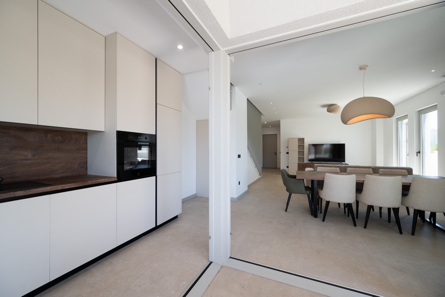 Coin repas avec vue sur le jardin et grandes baies vitrées
